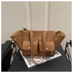 Detail of a brown lychee pattern leather tote bag with dual pockets and gold metal buckles