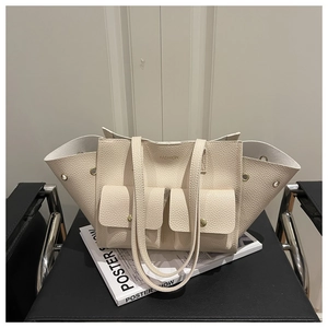 Close-up of beige lychee leather tote bag with functional double front pockets