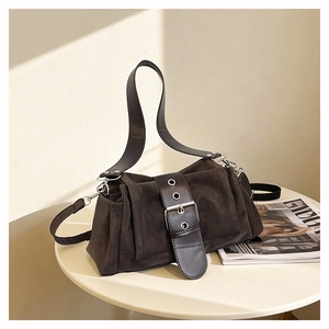 Détail du sac à bandoulière marron foncé mat avec boucle argentée et œillets en métal