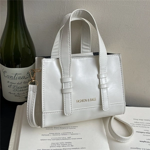 Minimalist white PU leather crossbody bag with top handles and golden lettering detail