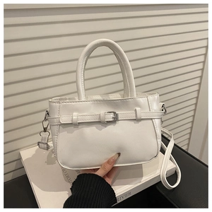 Detail of white PU leather handbag with silver buckle strap and adjustable top handle