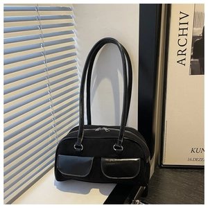 Detail der schwarzen Baguette-Tasche mit zwei Klapptaschen und silbernen Reißverschlüssen
