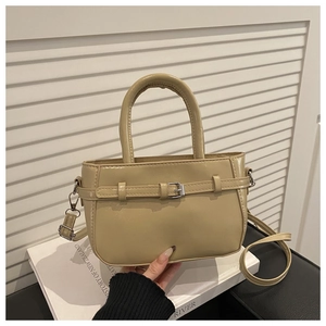 Detail of khaki leather handbag with decorative belt buckle and adjustable shoulder strap