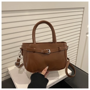 Detail of a brown leather mini bag with belt buckle and detachable shoulder strap