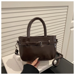 Detail of dark brown vintage crossbody bag with stylish belt buckle decoration