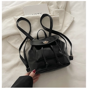 Close-up of small black PU leather backpack with gold clasp and drawstring detail
