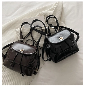 Detail of mini glossy PU leather backpacks with gold twist locks in black and coffee