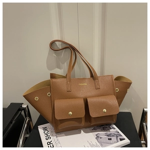 Close-up of brown pebbled leather tote bag featuring two front pockets and golden logo