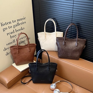 Collection de sacs seaux chic en cuir mat en quatre couleurs sur un canapé
