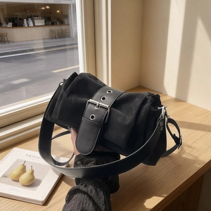 Sac à épaule rétro en suédine noire avec boucle décorative sous une lumière naturelle
