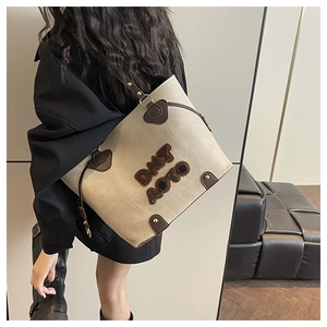 Detail view of large retro tote bag with DMT AUTO embroidery and gold rivet accents