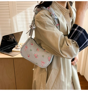 Detailed texture of blue floral shoulder bag with pink roses and ribbon bow prints