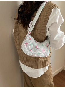 Detail of floral canvas shoulder bag with 3D quilted texture and pink bow patterns