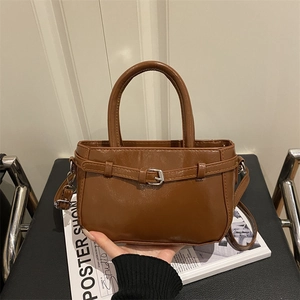 Brown faux leather crossbody bag with decorative belt buckle and top handle design