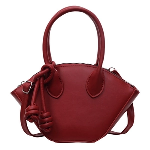 Sac coquillage moderne en cuir rouge avec design ailé et détail de nœud tissé décoratif