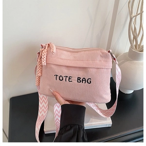 Detail of pink corduroy tote bag with TOTE BAG embroidery and patterned wide strap