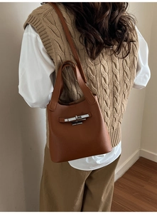 Vue détaillée du sac seau en cuir marron texturé avec fermoir rotatif argenté élégant