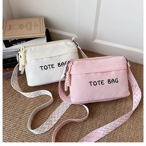 Detail view of corduroy tote bags with wide ethnic straps in beige and pink colors