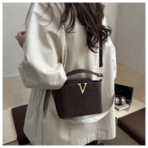 Détail du sac à main en cuir marron avec boucle en V dorée et bandoulière réglable