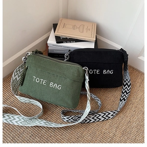 Close-up of corduroy tote bags with letter embroidery and geometric pattern straps