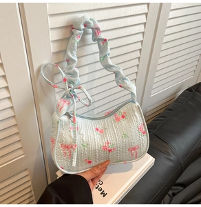 Detail of light blue floral pleated fabric and scrunchie strap on stylish handbag