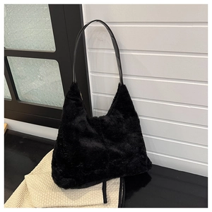 Close-up of black faux fur tote bag with smooth PU leather shoulder strap on waffle fabric