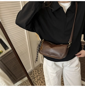 Brown vintage leather crossbody bag worn by model with casual autumn outfit