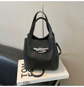 Detail of black lychee grain leather bucket bag featuring a silver designer metal clasp