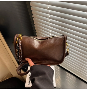 Macro view of vintage brown PU leather tote with woven rope and gold hardware detail