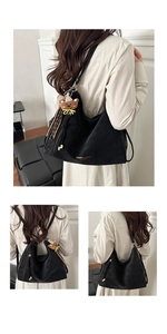 Detail view of black vintage tote bag featuring a cute bear charm and logo print