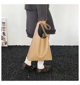 Detail view of large khaki leather tote bag with gold FASHION text for women