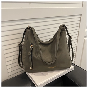 Close-up of deep olive green matte PU leather tote bag with gold logo and tassel zipper detail