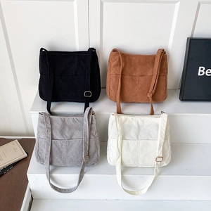 Minimalist corduroy bucket shoulder bags in four solid colors displayed on a white stand