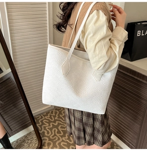 Détail du grand sac cabas blanc à texture tressée et anses renforcées pour le bureau