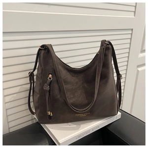 Detail of dark brown faux leather tote with golden lettering and fringe zipper pocket