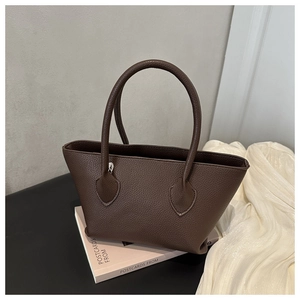 Detailed macro view of the dark brown lychee texture leather on this stylish bucket tote bag