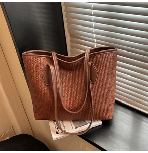 Detailed close-up of dark brown woven texture on a large capacity tote bag with dual straps
