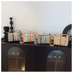 Quatre mini-sacs carrés tissés à rayures colorées sur une étagère vintage noire