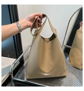 Détail du sac cabas minimaliste en cuir kaki avec logo doré et poignée supérieure