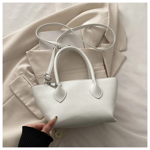 Close-up of white lychee pattern leather texture and silver hardware on a bucket bag