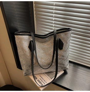Détail du sac cabas matelassé argenté avec poignées noires dans un cadre de vie moderne