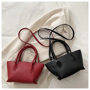 Close-up of red and black lychee texture bucket bags with silver hardware and thin straps