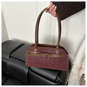 Detail of burgundy leopard print suede tote bag with leather straps and gold buckle