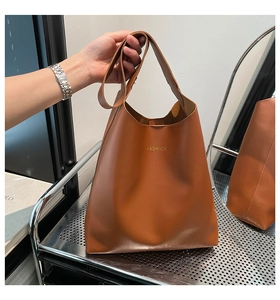 Détail du sac seau marron en similicuir avec texte doré fashion sur support métal