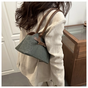 Detail view of dark green vintage shoulder bag with brown leather trim and metal buckle