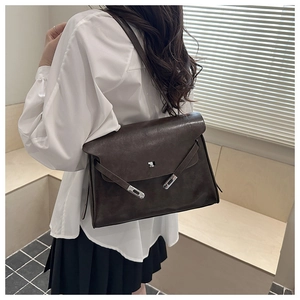Detailed side view of vintage dark brown leather tote bag with metallic buckle