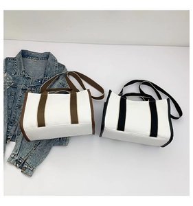Flat lay of canvas tote bags in brown and black with denim jacket and glass props