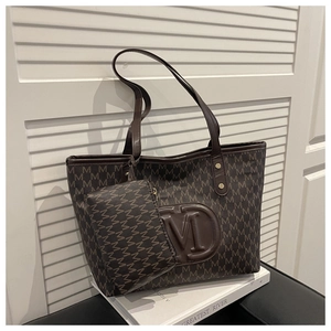 Dettaglio macro della borsa tote marrone scuro con logo M a rilievo e monogramma