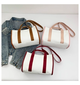 Three minimalist canvas tote bags in various colors with adjustable webbing straps