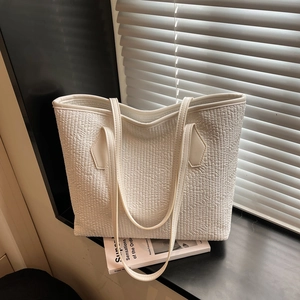 White woven texture tote bag with slim shoulder straps on a window sill for daily commute